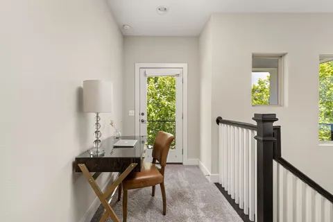 a view of a workspace with furniture and a window