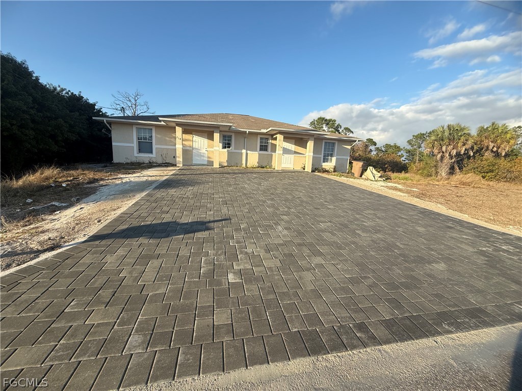 218 West 12th Street Lehigh Acres, FL 33972 - Photo 2 of 8 a front view of a house with a yard