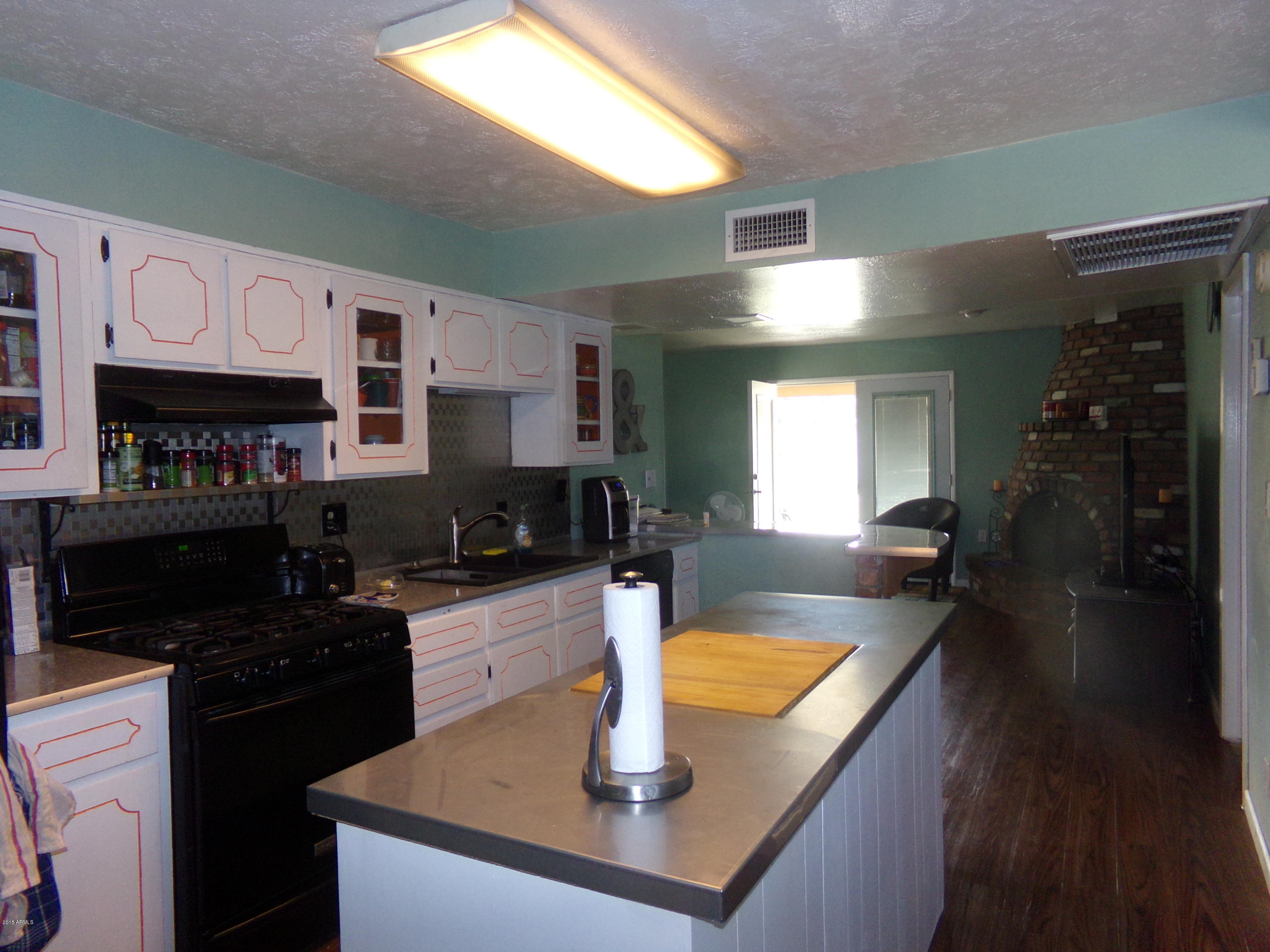 1221 West Mountain View Road Phoenix, AZ 85021 - Photo 5 of 12 a kitchen with kitchen island granite countertop a sink a counter top space and cabinets