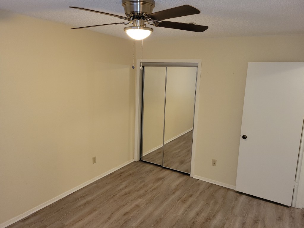 1015 East Yager Lane, Unit 69 Austin, TX 78753 - Photo 9 of 16 an empty room with wooden floor fan and windows