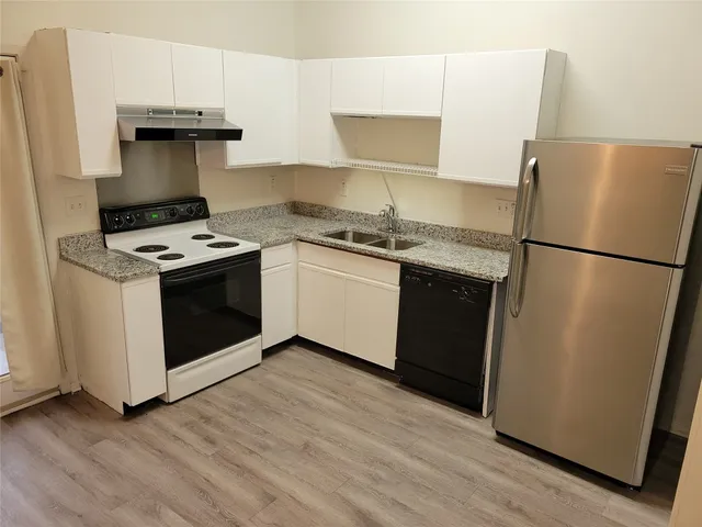 a kitchen with a stove top oven and refrigerator