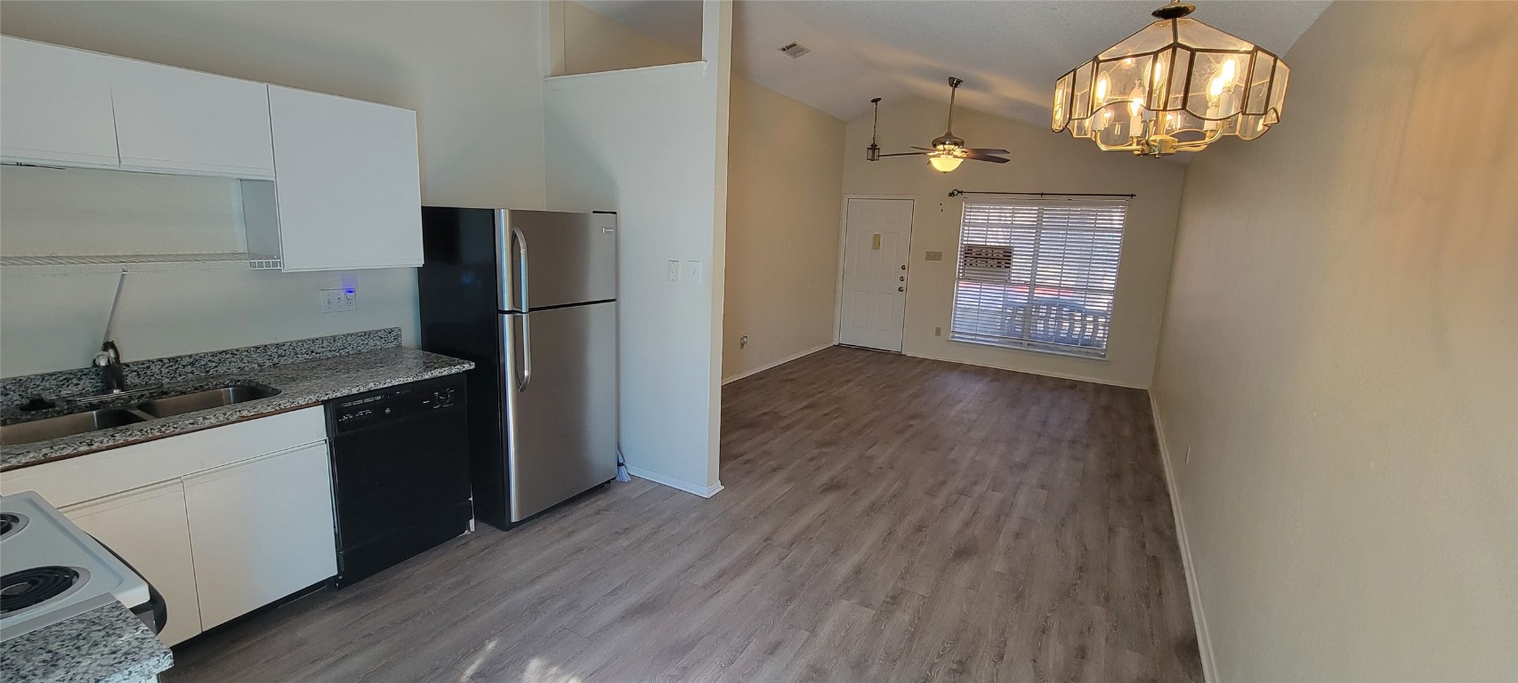 1015 East Yager Lane, Unit 69 Austin, TX 78753 - Photo 5 of 16 a kitchen with granite countertop a refrigerator and a stove top oven