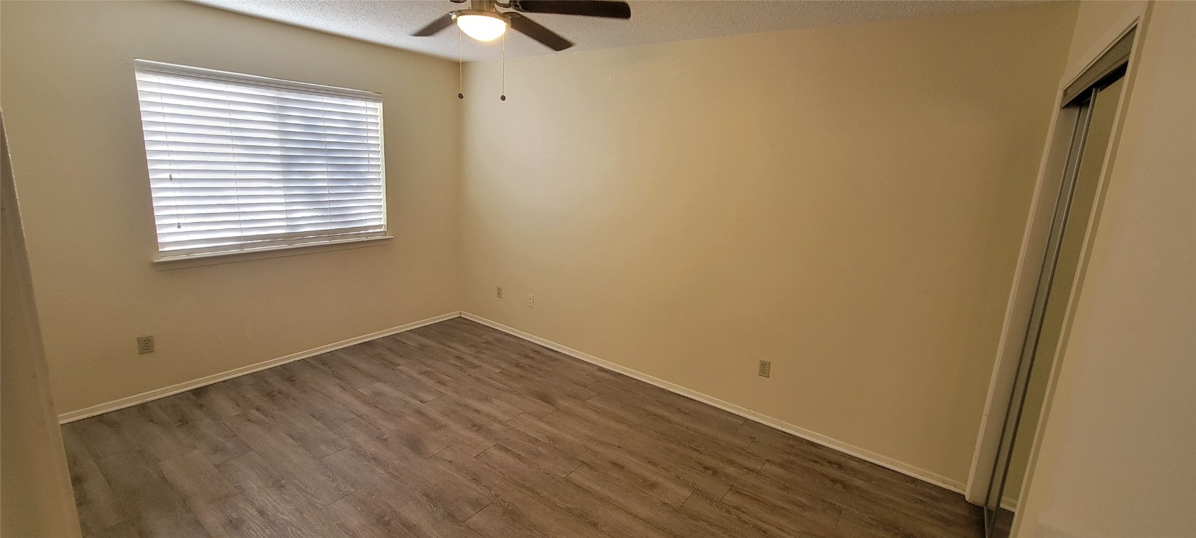 1015 East Yager Lane, Unit 69 Austin, TX 78753 - Photo 8 of 16 a view of an empty room with wooden floor and a window