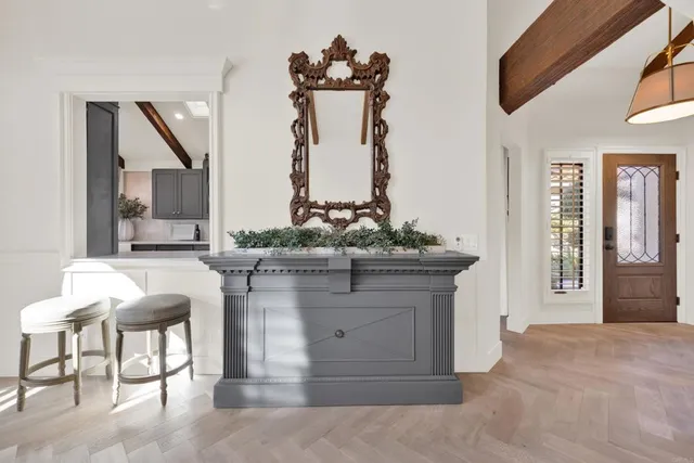 a dining room with furniture a chandelier and a large window