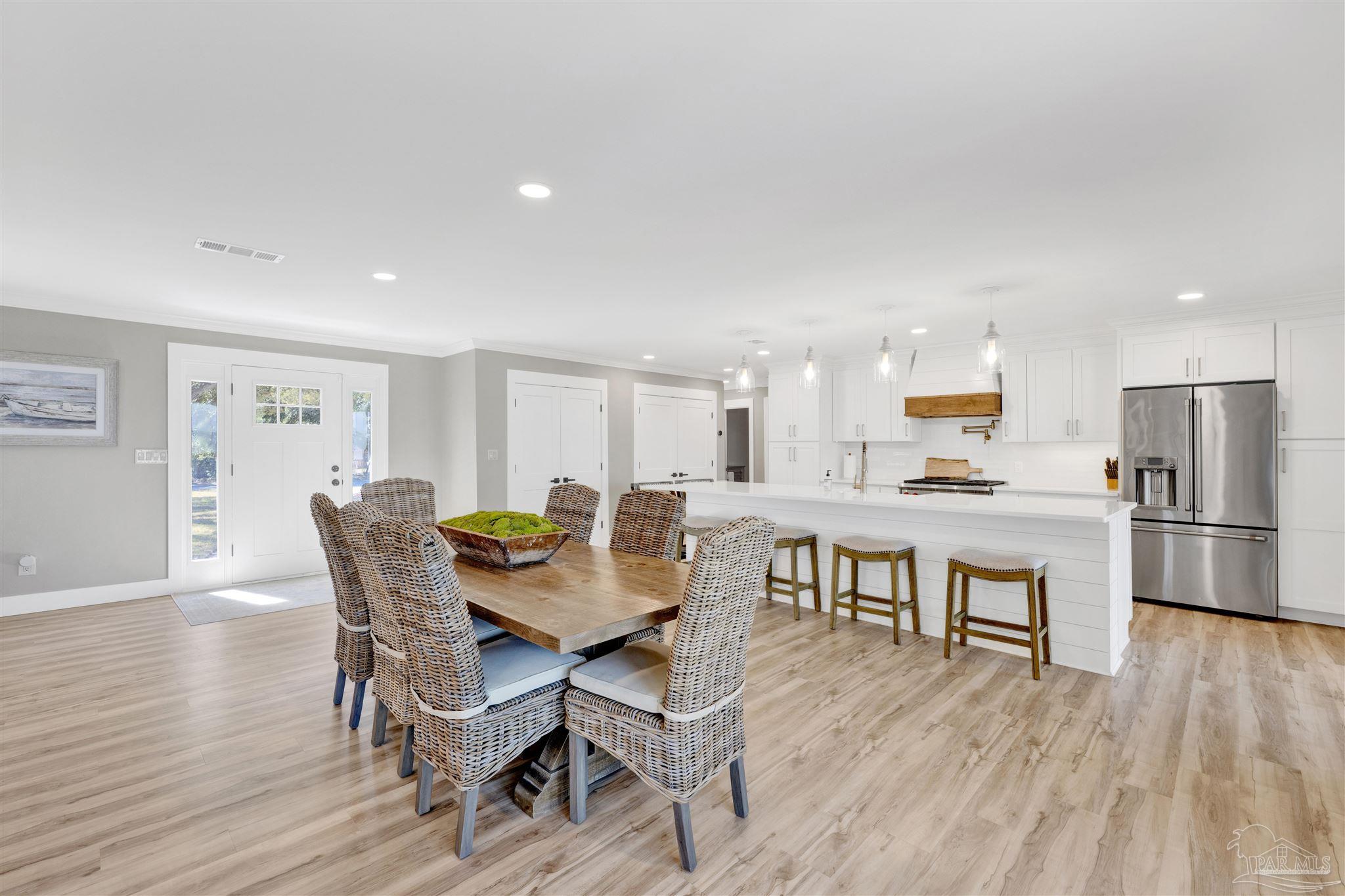 5470 North Shore Road Pensacola, FL 32507 - Photo 15 of 63 a view of a dining room with furniture and wooden floor