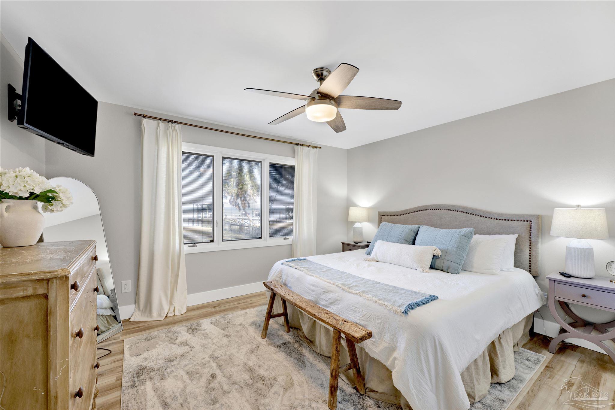 5470 North Shore Road Pensacola, FL 32507 - Photo 31 of 63 a bedroom with a bed and a flat tv screen on dresser