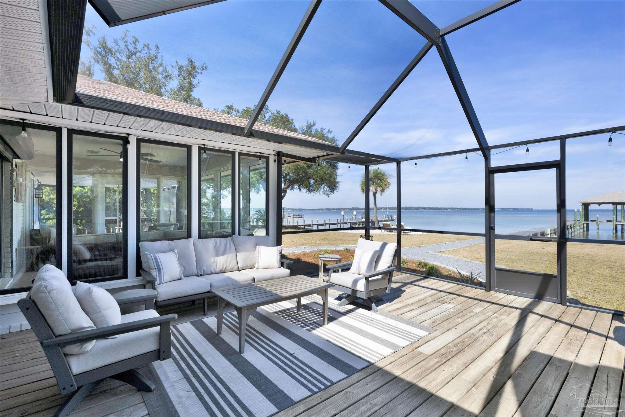 5470 North Shore Road Pensacola, FL 32507 - Photo 6 of 63 a living room with a rug floor to ceiling window and deck