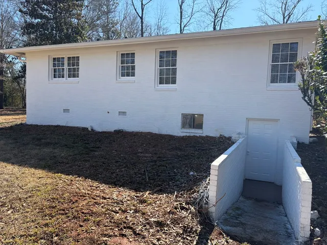 a front view of a house with a yard and potted plants