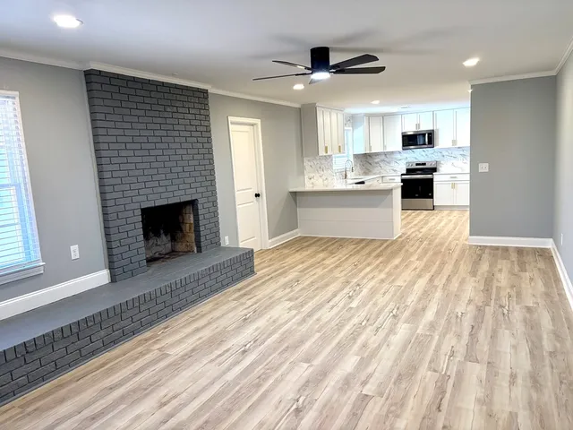 a large white kitchen with granite countertop lots of counter top space and stainless steel appliances
