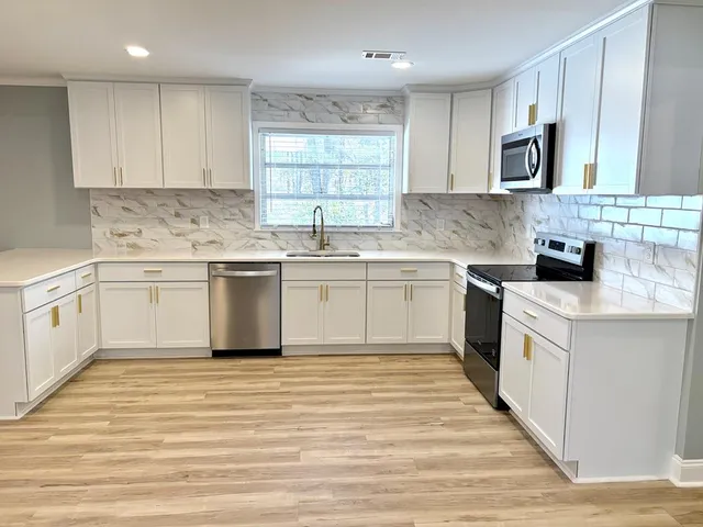 a kitchen with a sink stove cabinets and refrigerator