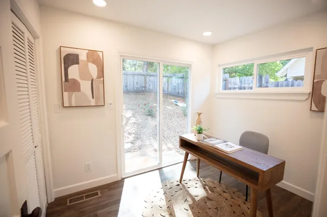 a view of a workspace with furniture and wooden floor