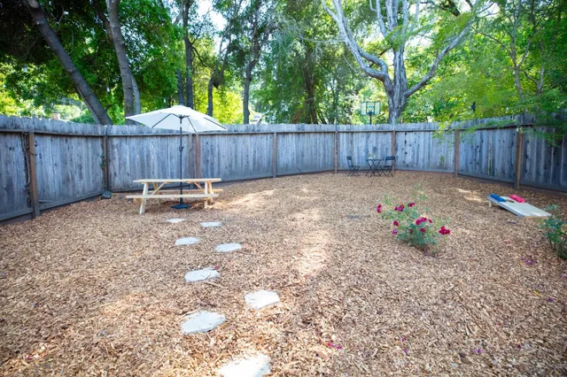 a view of a backyard with wooden fence