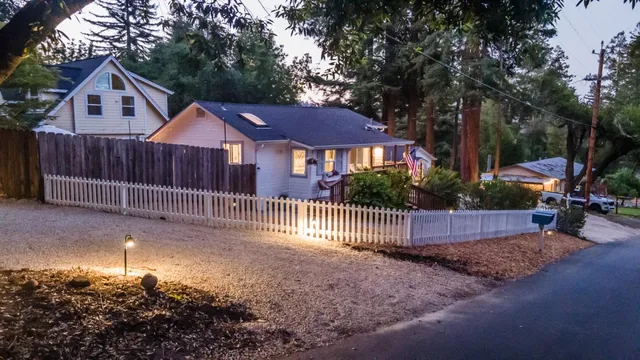 a view of a yard with wooden fence and trees