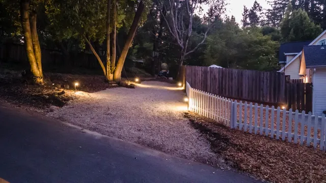 a view of a wooden house with a small yard and wooden fence