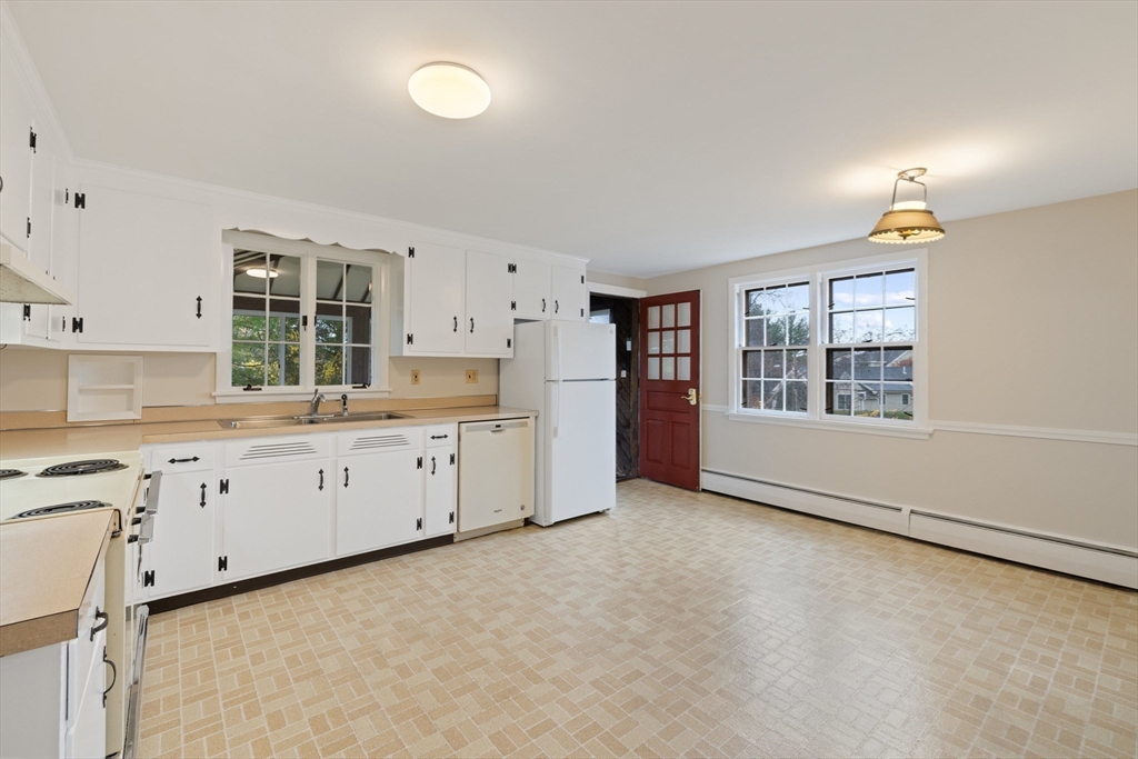 45 Peach Highlands Marblehead, MA 01945 - Photo 6 of 21 a large white kitchen with granite countertop a stove a sink a window and a refrigerator