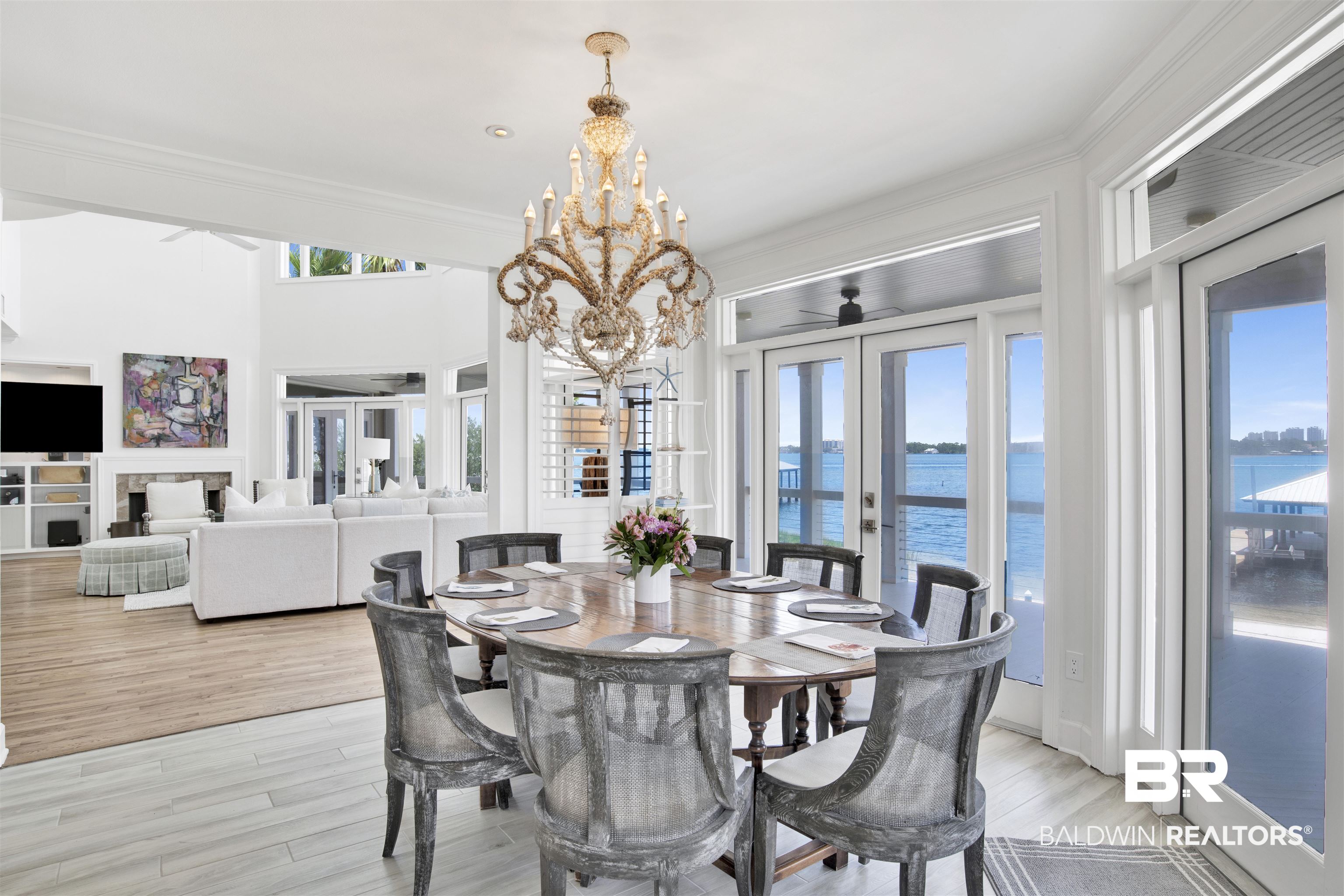 33400 River Road Orange Beach, AL 36561 - Photo 26 of 72 Dining area featuring a notable chandelier, light hardwood / wood-style flooring, a water view, and french doors