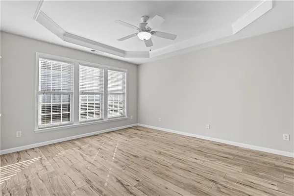 a view of a livingroom with a chandelier fan and wooden floor
