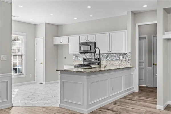 a kitchen with stainless steel appliances granite countertop a stove a sink and a refrigerator