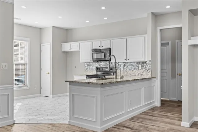 a kitchen with stainless steel appliances granite countertop a stove a sink and a refrigerator