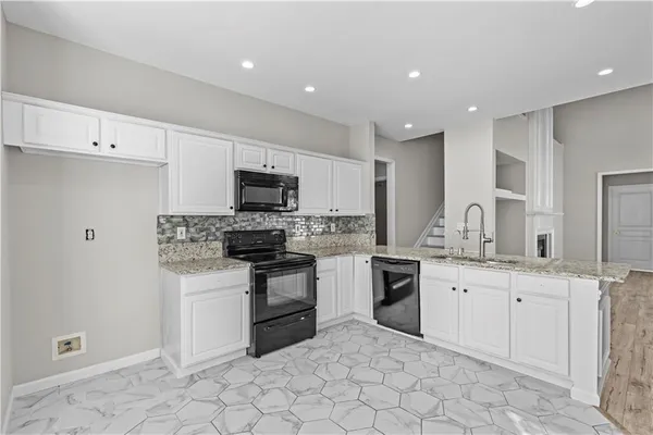 a kitchen with white cabinets stainless steel appliances and sink