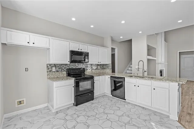 a kitchen with white cabinets stainless steel appliances and sink