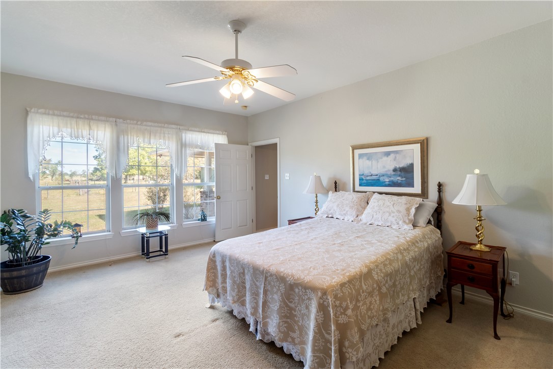 28109 Waller Gladish Road Waller, TX 77484 - Photo 11 of 28 a bedroom with a bed and a chandelier
