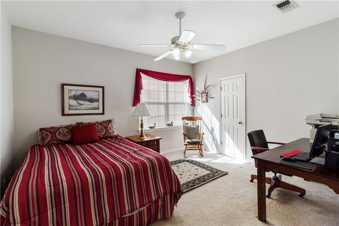 28109 Waller Gladish Road Waller, TX 77484 - Photo 18 of 28 a bedroom with a bed and a chandelier