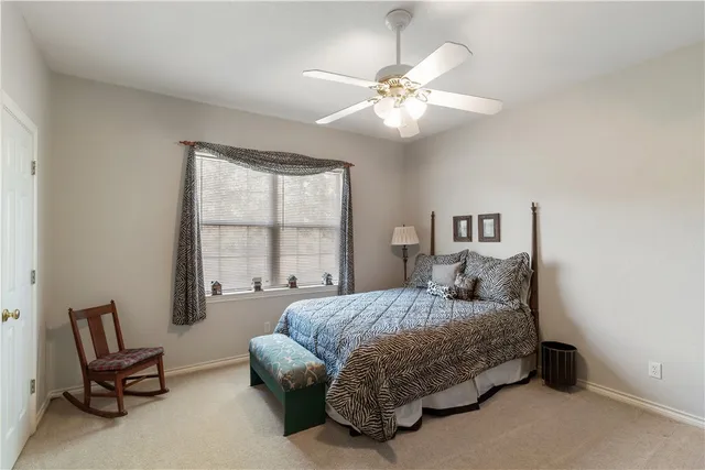 a bedroom with a bed a chair and painting on the wall