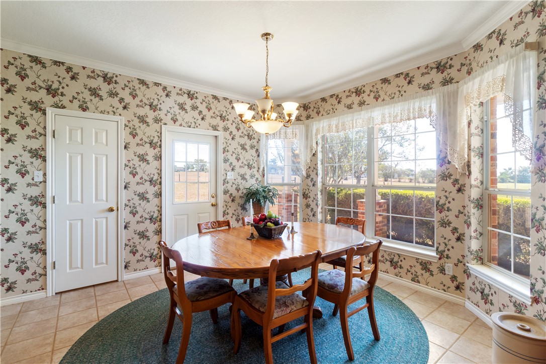 28109 Waller Gladish Road Waller, TX 77484 - Photo 25 of 28 a dining room with furniture a chandelier and wooden floor
