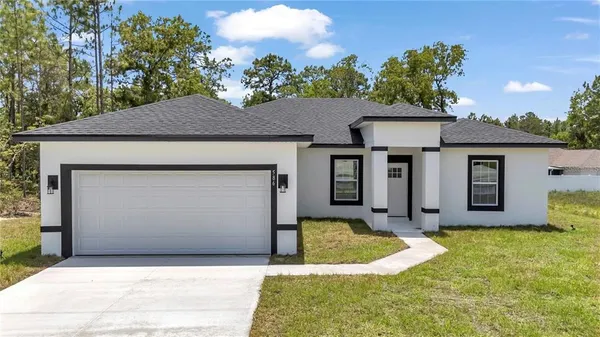 a front view of a house with a yard garage and outdoor seating