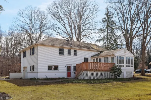 a front view of a house with large windows and a large tree