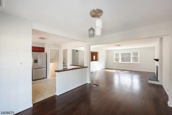 a view of a kitchen with a sink a refrigerator and wooden floor