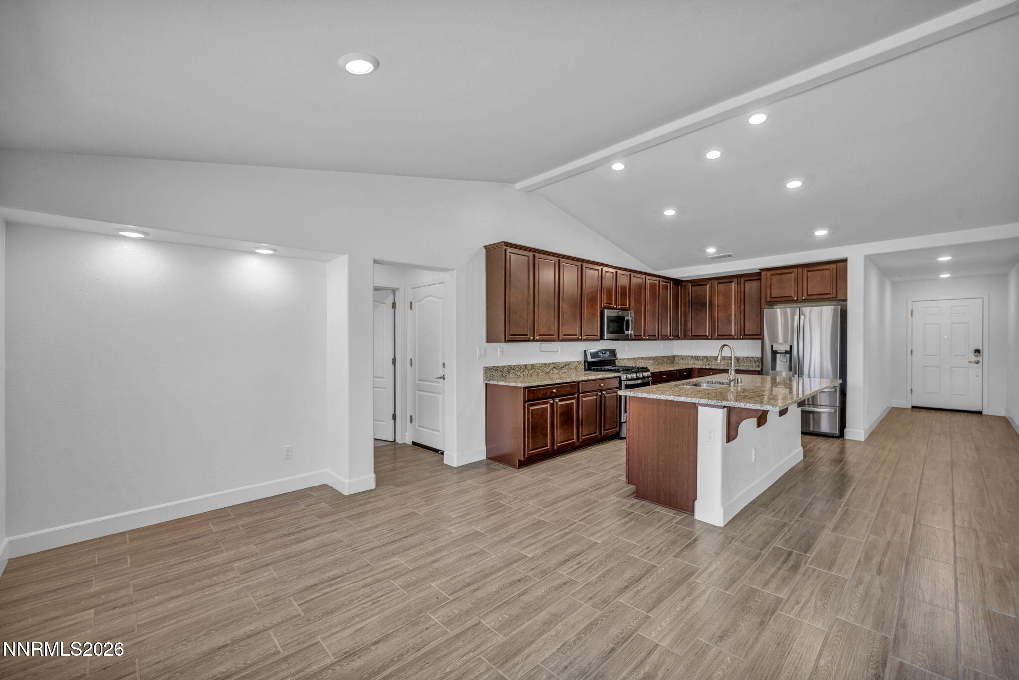 7181 Saddlehorn Road Carson City, NV 89701 - Photo 24 of 62 a kitchen with stainless steel appliances kitchen island granite countertop a refrigerator and a sink