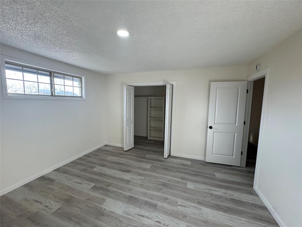 408 Steeple Ridge Road Everman, TX 76140 - Photo 11 of 14 a view of an empty room with wooden floor and window