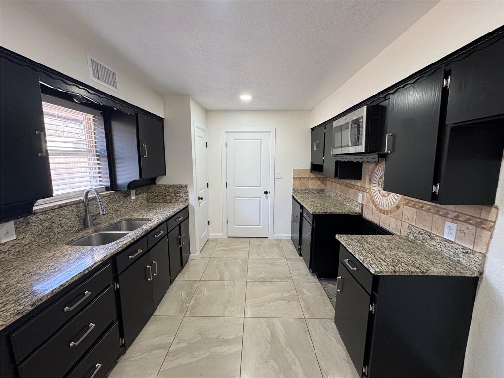 408 Steeple Ridge Road Everman, TX 76140 - Photo 5 of 14 a large kitchen with stainless steel appliances granite countertop a sink stove and refrigerator