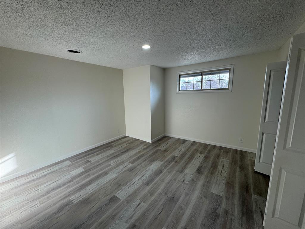 408 Steeple Ridge Road Everman, TX 76140 - Photo 10 of 14 a view of an empty room with wooden floor and a window