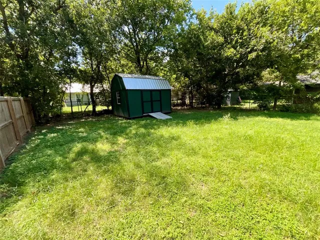 a view of a backyard with large trees and plants