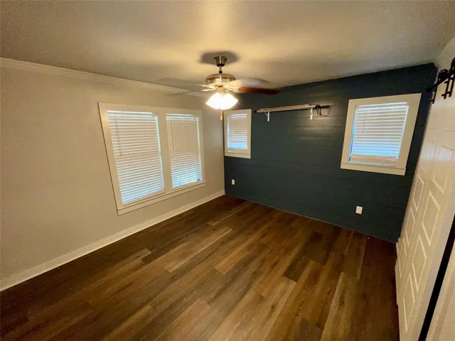 a view of empty room with a ceiling fan and window