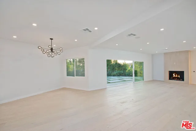 a view of a yard in front of a house with a large tree