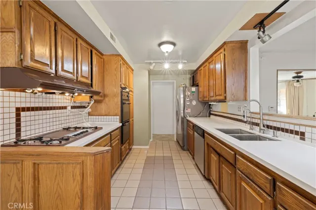 a kitchen with stainless steel appliances a sink stove and cabinets