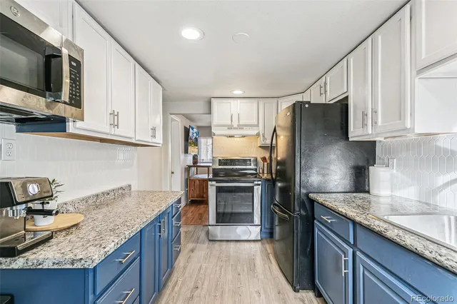 a kitchen with granite countertop a sink stove and refrigerator