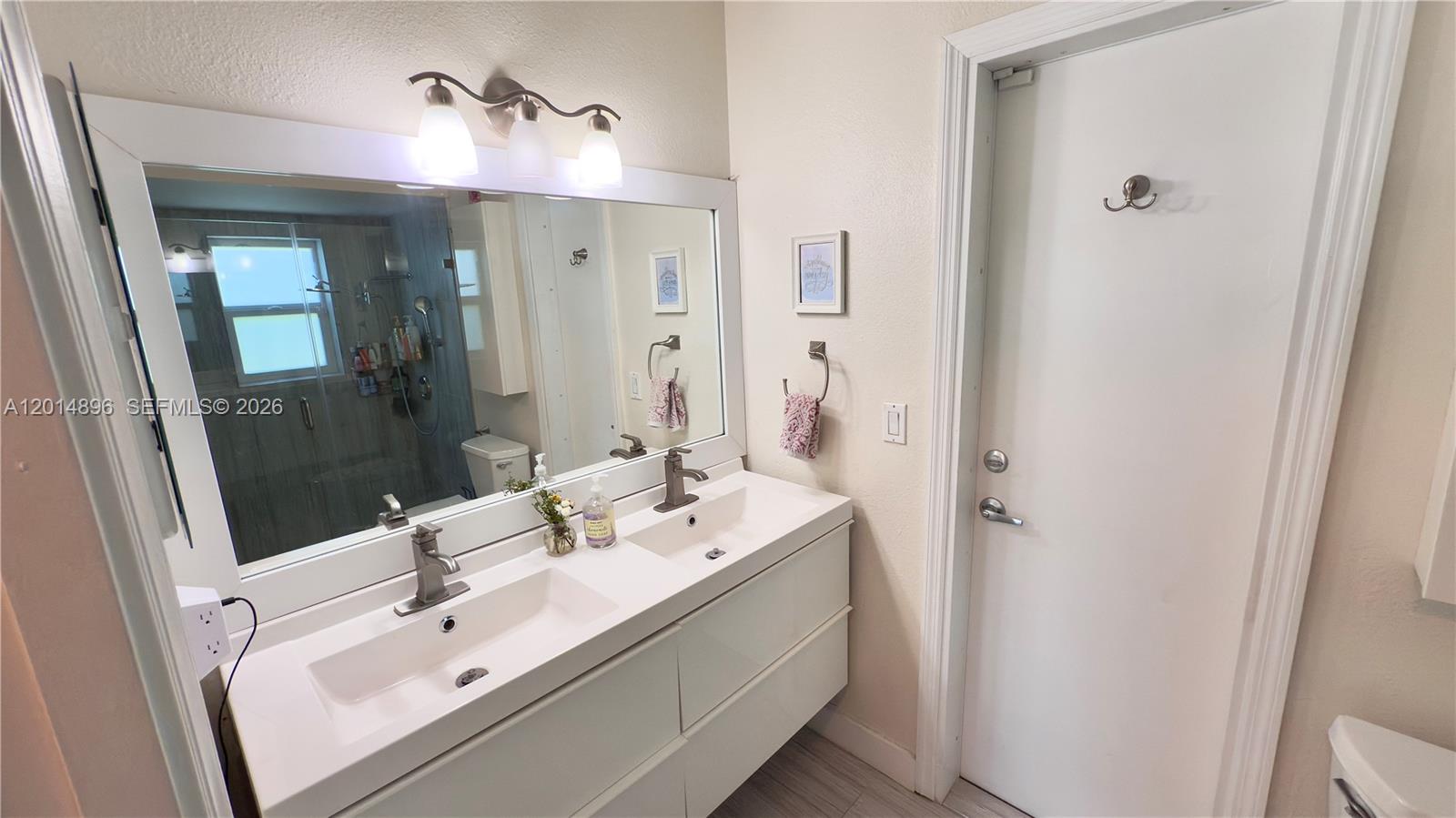 2411 Northwest 31st Street Boca Raton, FL 33431 - Photo 22 of 43 a en suite bathroom with a sink a mirror and a shower