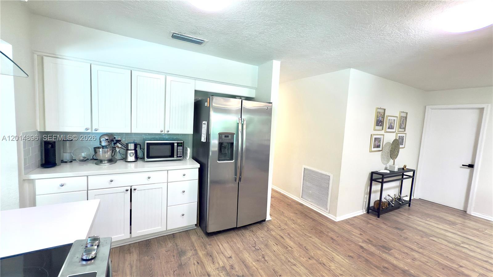 2411 Northwest 31st Street Boca Raton, FL 33431 - Photo 8 of 43 a kitchen with stainless steel appliances a refrigerator and wooden floor