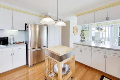a kitchen with refrigerator cabinets and wooden floor
