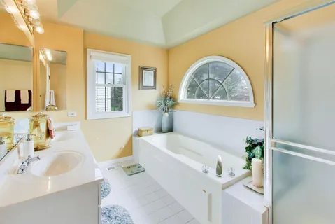 a bathroom with a tub sink and mirror