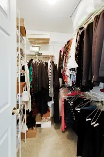 a view of walk in closet with clothes and shoes