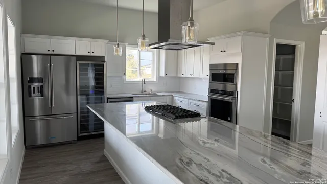 a kitchen with stainless steel appliances a refrigerator and a stove top oven