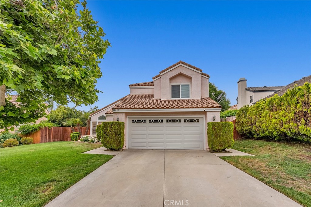 a front view of a house with a garden and garage