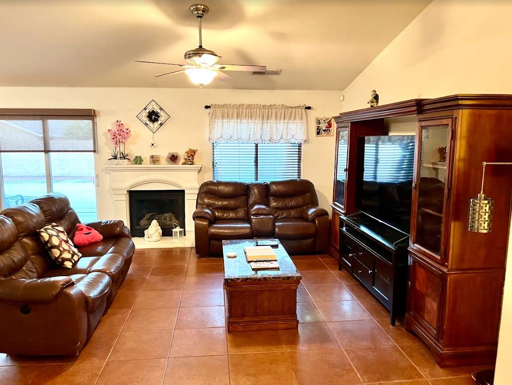 922 Sequoia Street Parlier, CA 93648 - Photo 2 of 16 a living room with furniture a flat screen tv and a fireplace