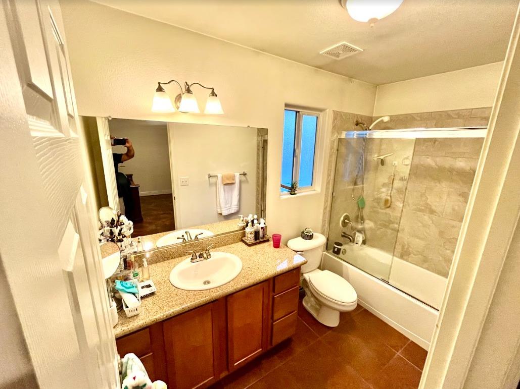 922 Sequoia Street Parlier, CA 93648 - Photo 10 of 16 a bathroom with a sink a toilet a mirror and shower